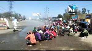बरेली में मजदूरों पर केमिकल छिड़कते अधिकारी
